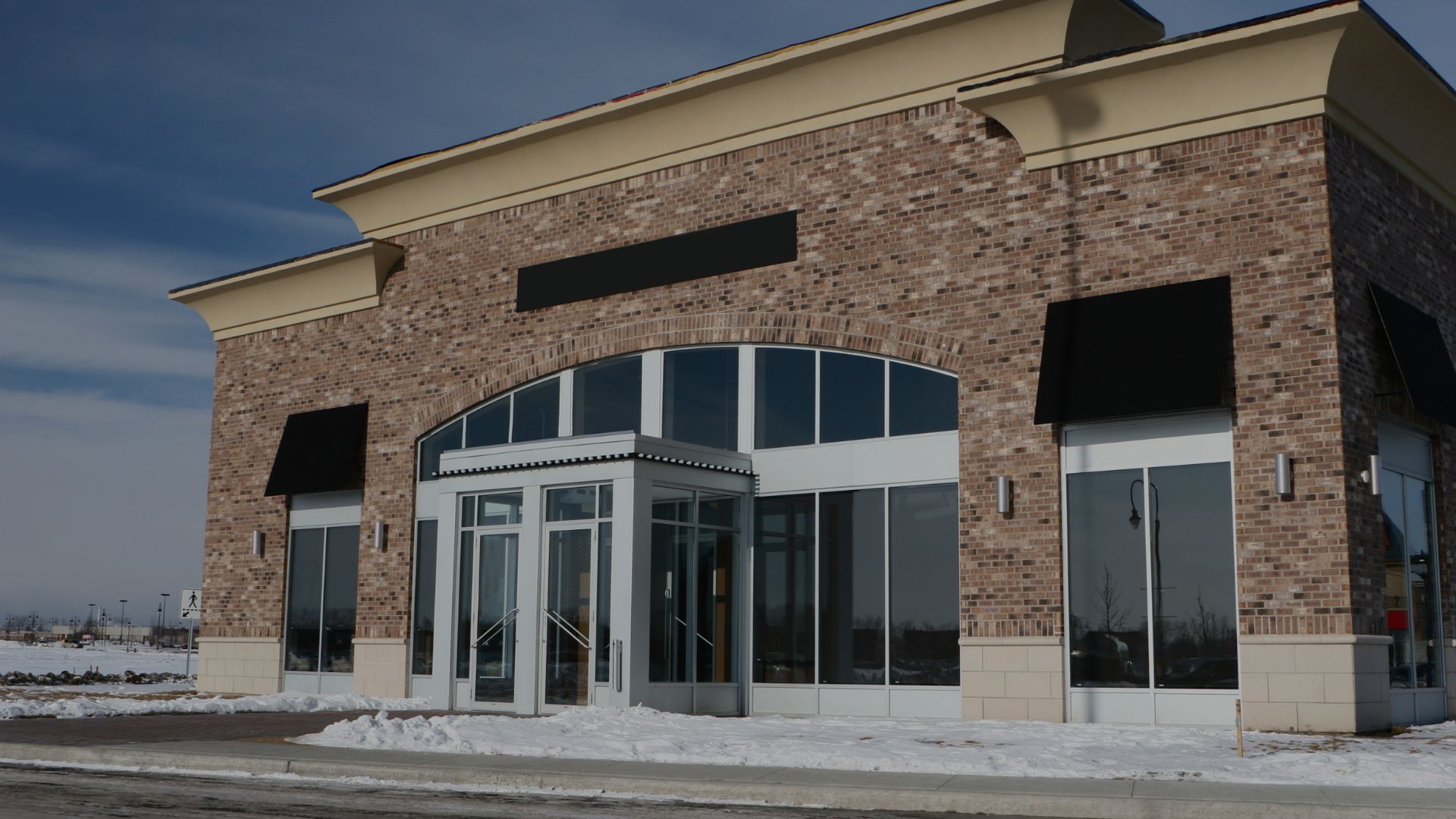 commercial building with snow in front of it